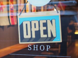 Open shop sign in a store as SAP and Google Cloud are deploying agentic commerce architecture to automate multi-agent marketing and retail operations at enterprise scale.